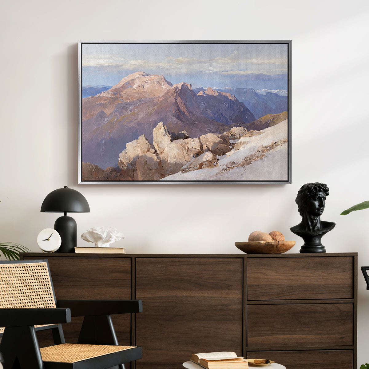 Hoher Göll from Watzmann-Hocheck, 1919 by Edward Theodore Compton displayed in a silver floater framed canvas above a dark wood credenza in an entryway.