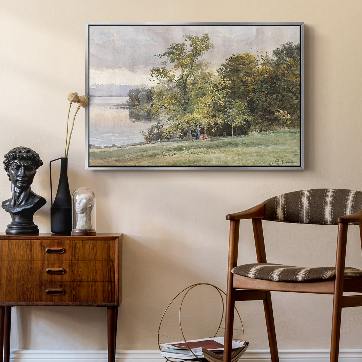 Landscape at Lake Starnberg, 1890 by Edward Theodore Compton as a silver floater framed canvas featuring a natural setting with water, trees, and open sky, styled above a mid-century console in a contemporary living area.