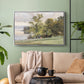 Silver floater framed canvas featuring a tranquil lakeside view with soft atmospheric tones, displayed above a sofa in a modern living room.