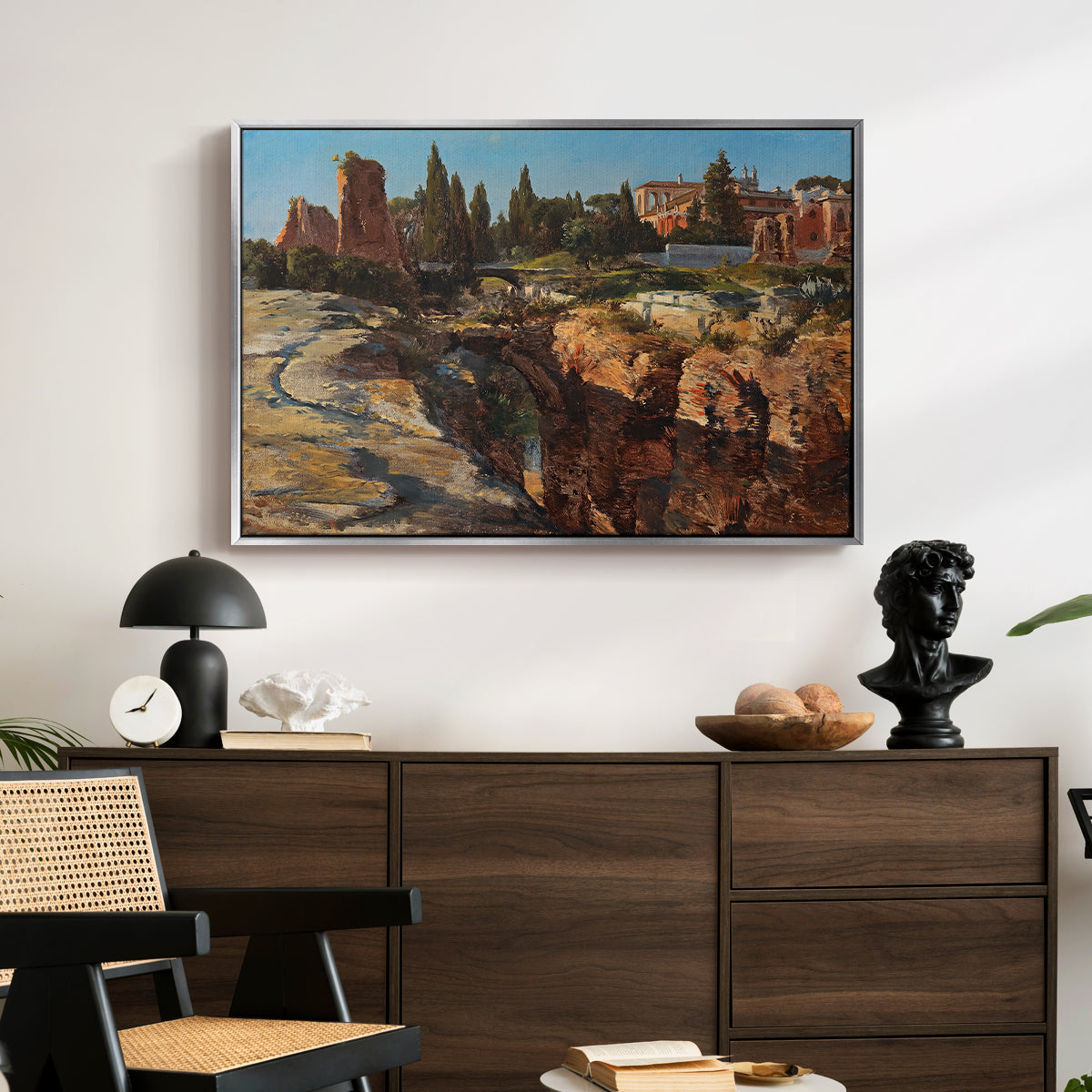 Palatine in Rome, c. 1921 by Edward Theodore Compton displayed in a silver floater framed canvas above a dark wood credenza in an entryway.