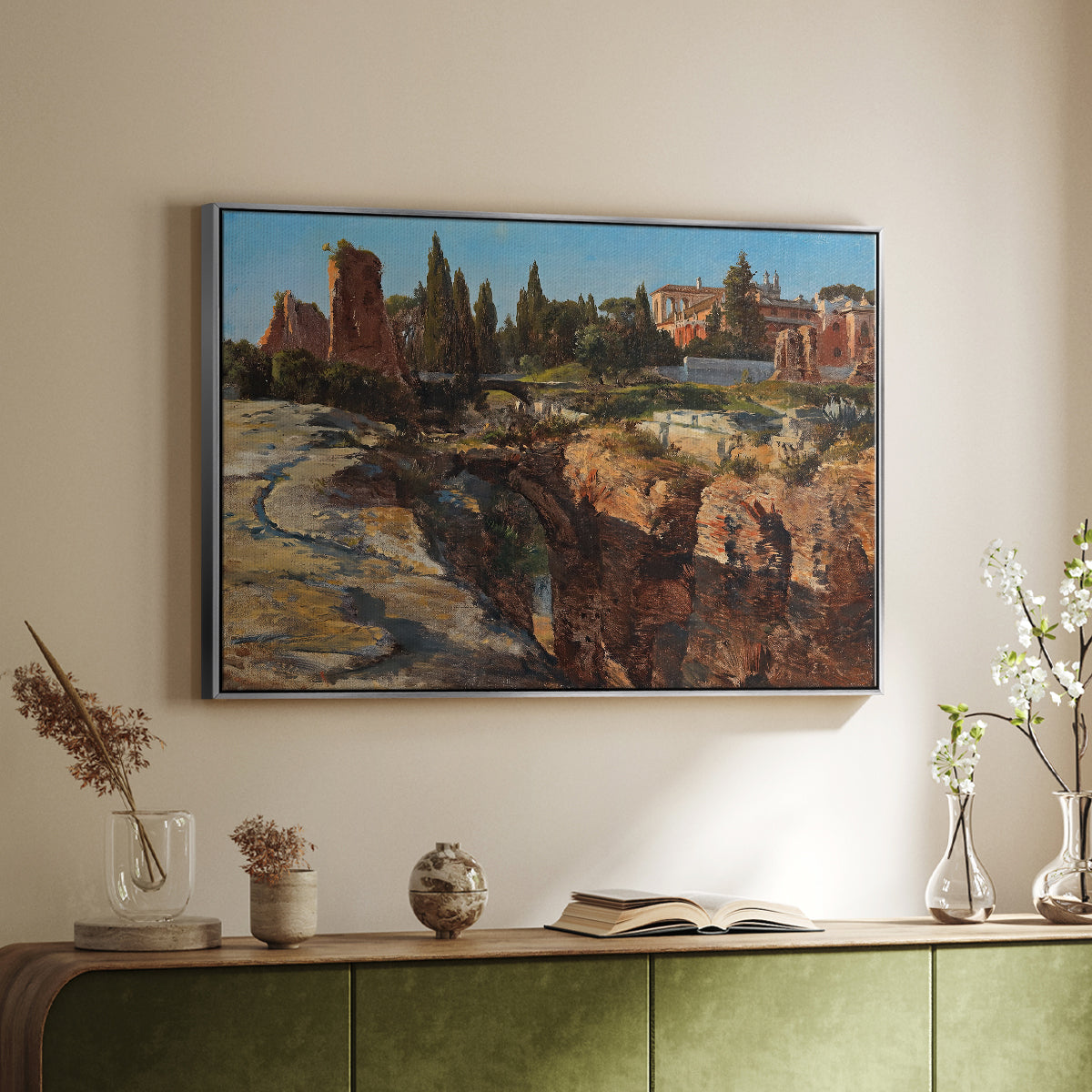 Silver floater framed canvas of Palatine in Rome, c. 1921 by Edward Theodore Compton, featuring an architectural scene of ancient structures in sunlit environment above a sideboard in a softly lit hallway.
