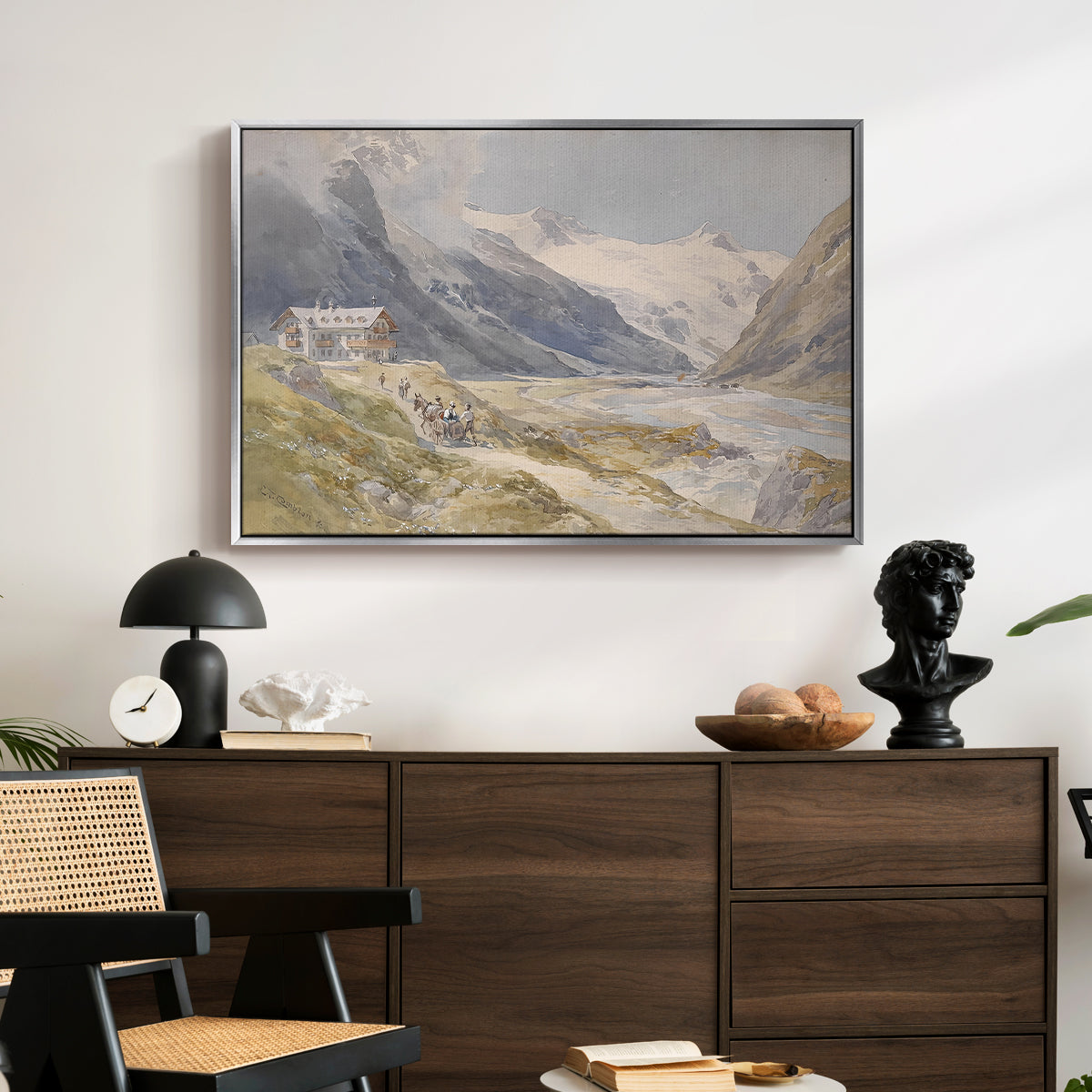 Shepherds (Pasterze), c. 1921 by Edward Theodore Compton displayed in a silver floater framed canvas above a dark wood credenza in an entryway.