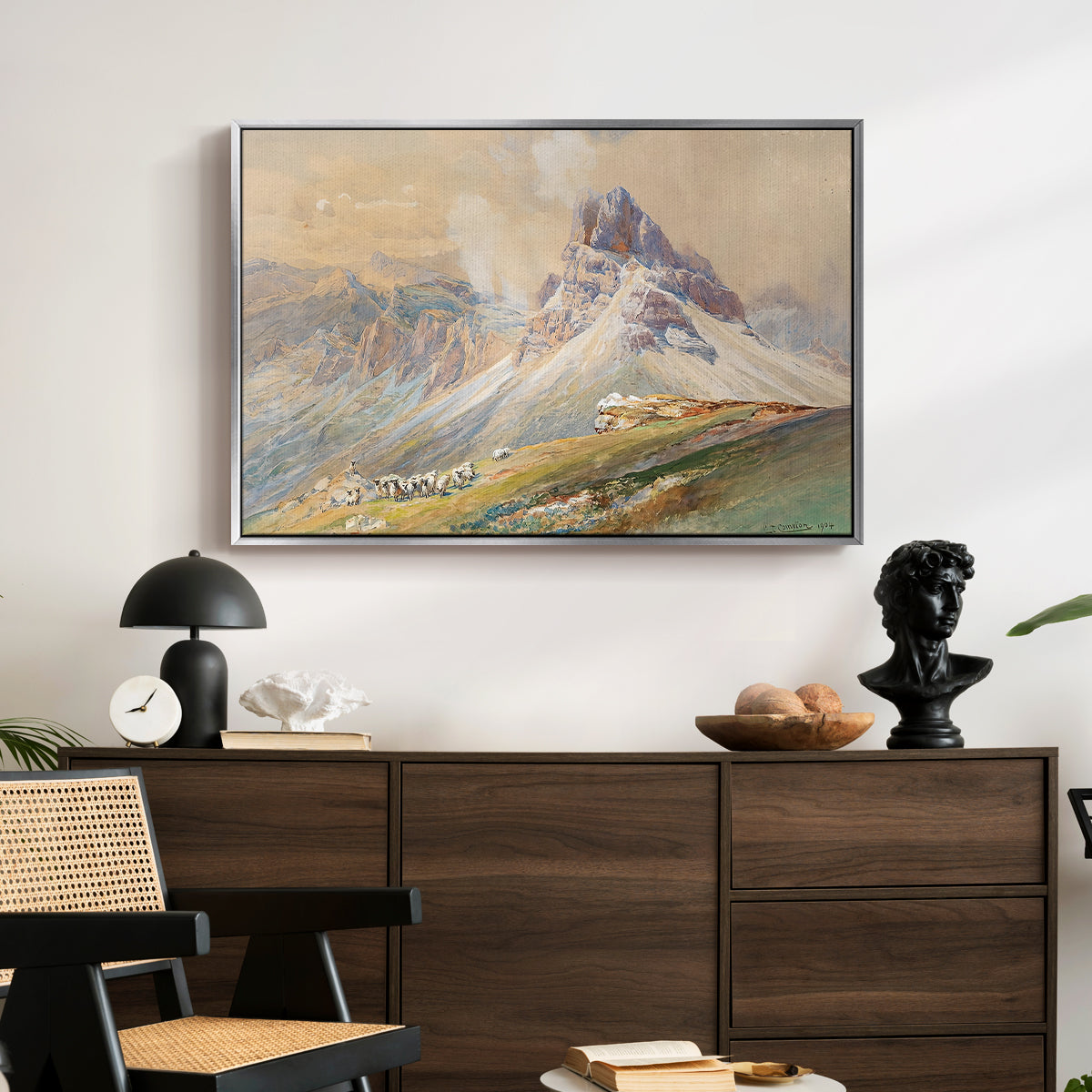 From the Dolomites, 1904 by Edward Theodore Compton displayed in a silver floater framed canvas above a dark wood credenza in an entryway.