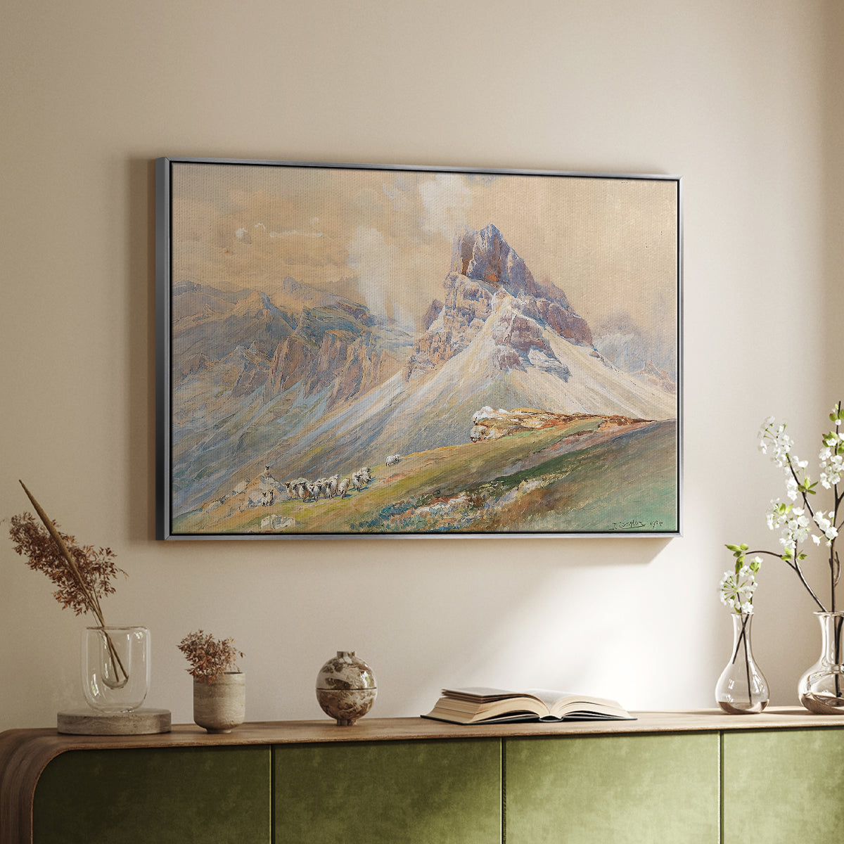 Silver floater framed canvas of From the Dolomites, 1904 by Edward Theodore Compton, featuring an alpine scene with jagged rock formations and distant mountains above a sideboard in a softly lit hallway.