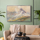 Silver floater framed canvas featuring a realistic mountain view with strong geological forms, displayed above a sofa in a modern living room.
