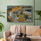Silver floater framed canvas featuring an architectural scene with houses arranged in curved composition, displayed above a sofa in a modern living room.