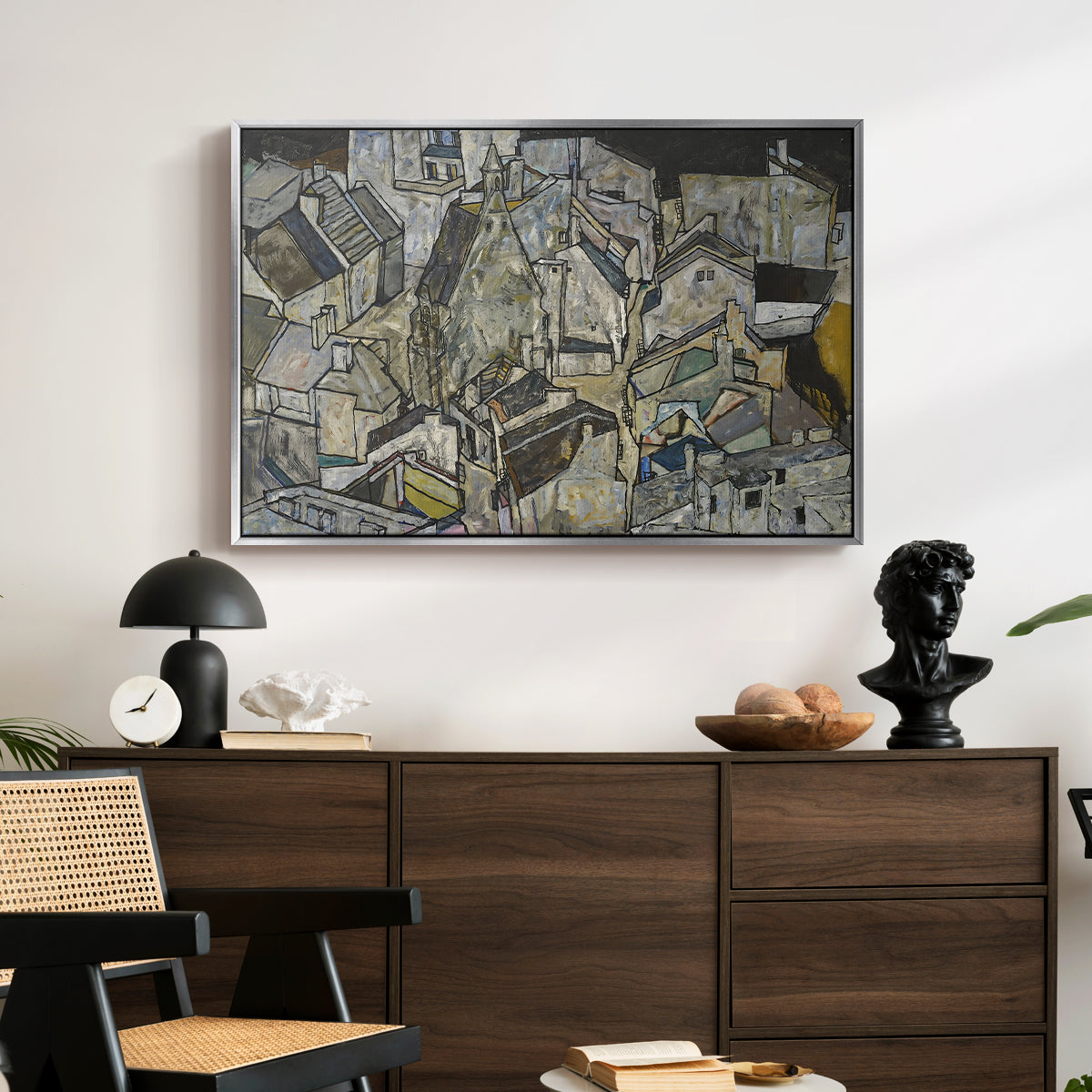 Mödling II, 1918 by Egon Schiele displayed in a silver floater framed canvas above a dark wood credenza in an entryway.