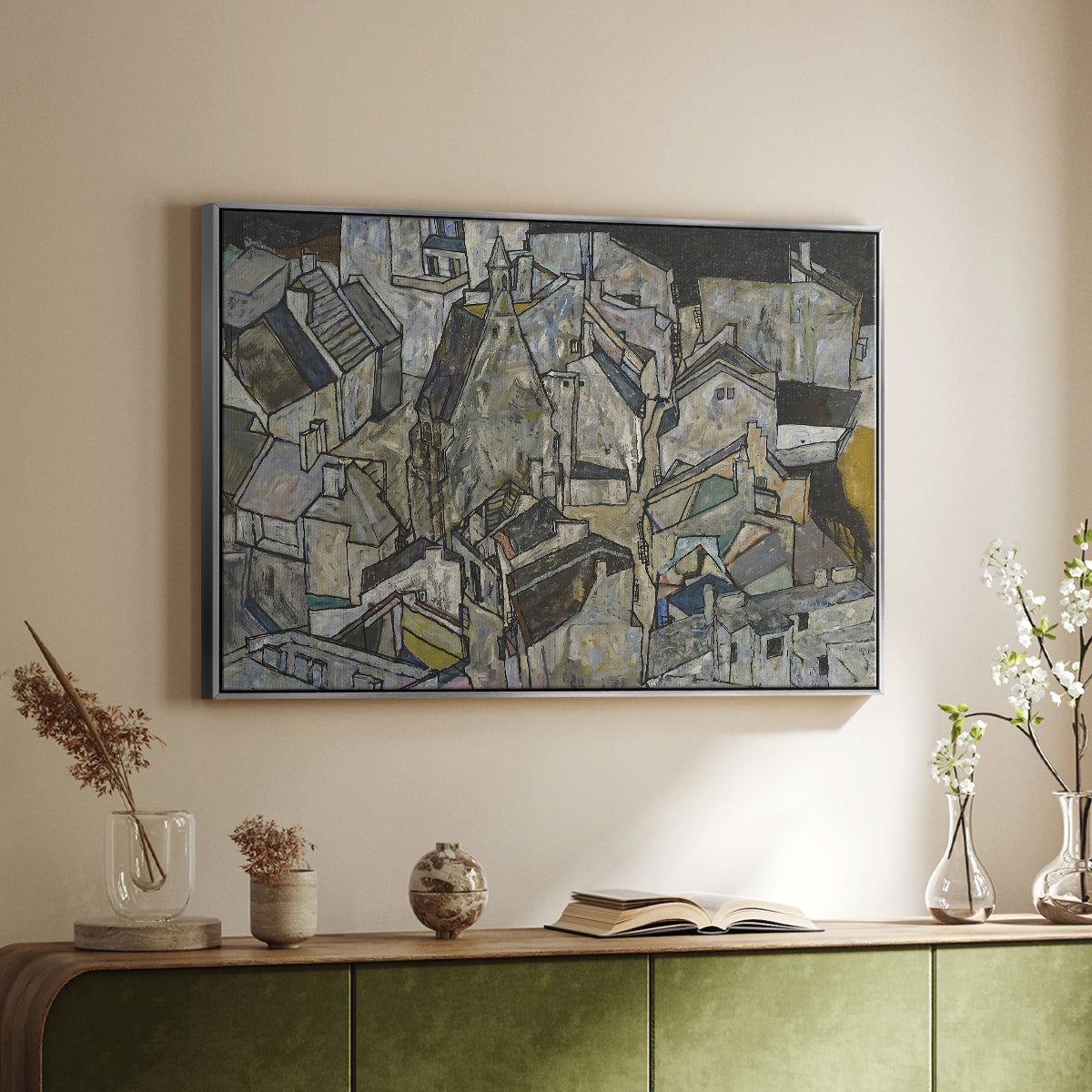 Silver floater framed canvas of Mödling II, 1918 by Egon Schiele, featuring an expressionist cityscape with tightly packed buildings and bold lines above a sideboard in a softly lit hallway.