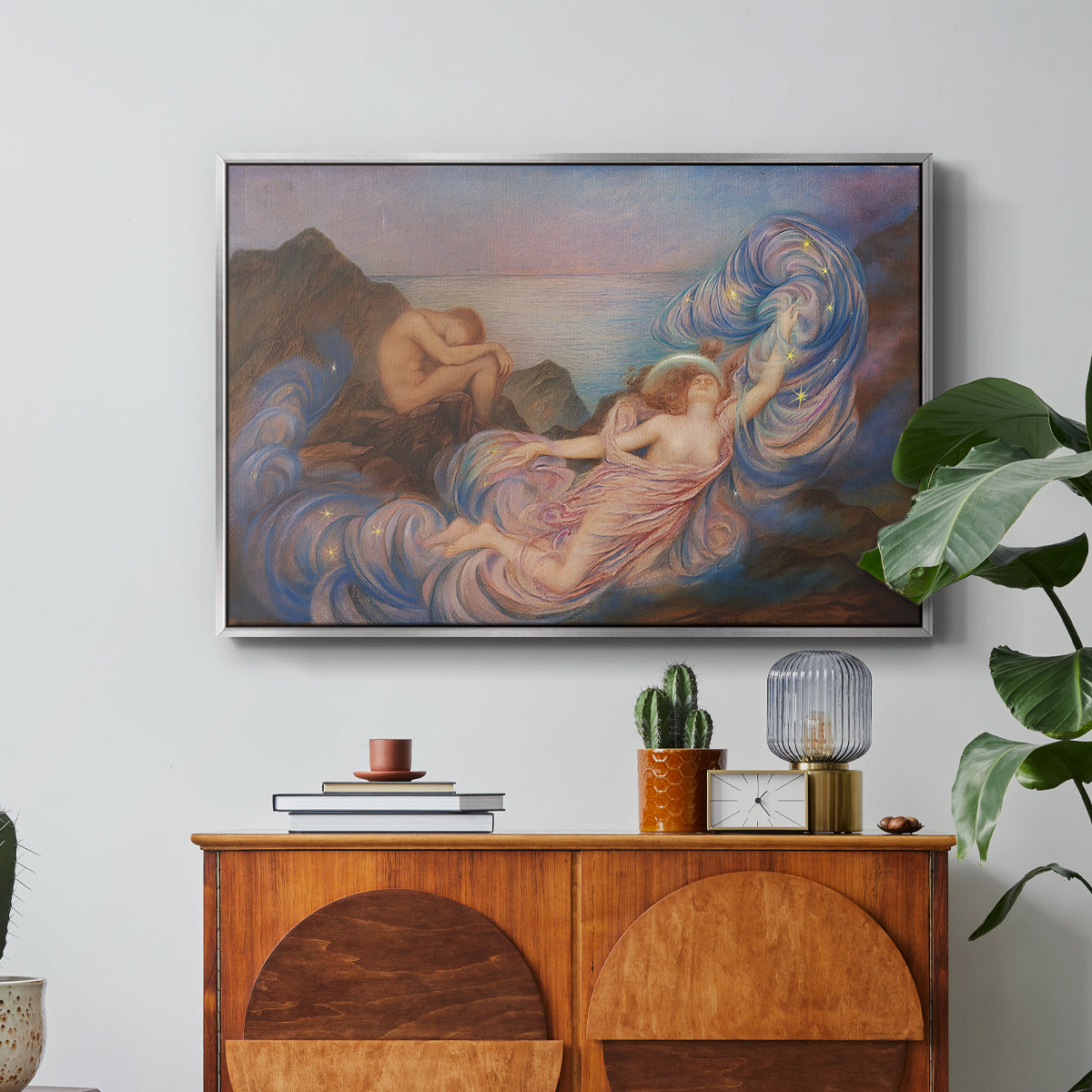 Twilight, 1914 by Evelyn De Morgan in a silver floater framed canvas featuring a reclining female figure beneath glowing sky at twilight with soft colors, displayed above a wood console cabinet.