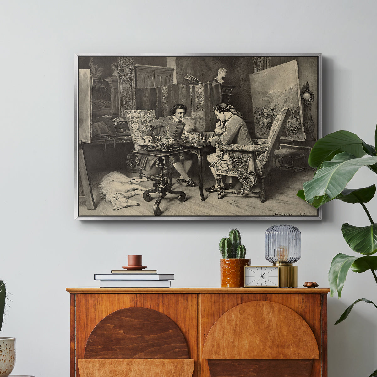 The Chess Players, 1858 by Ernest Meissonier in a silver floater framed canvas featuring two men seated at table playing chess in detailed interior setting, displayed above a wood console cabinet.