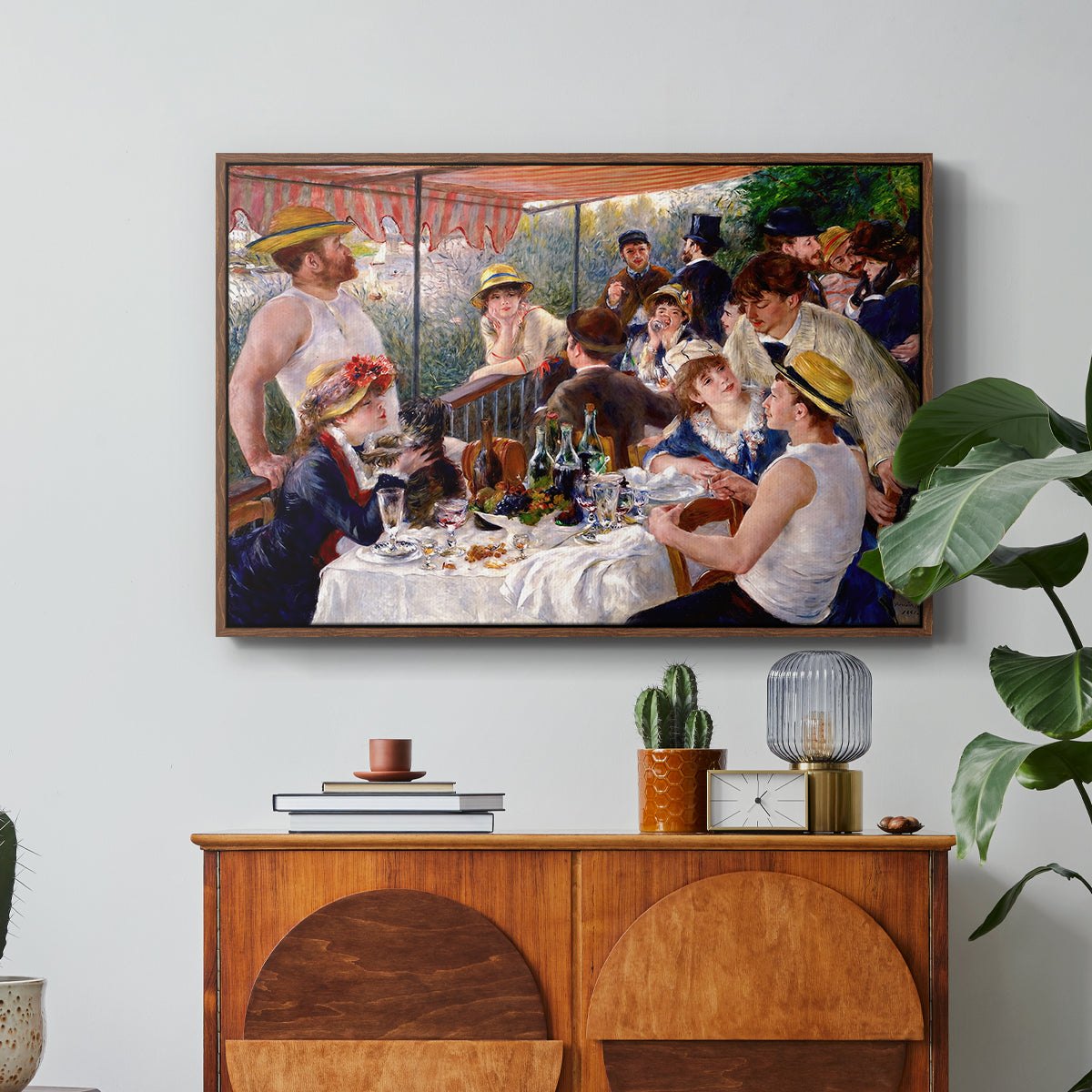 Luncheon of the Boating Party (Le Déjeuner des canotiers), 1880-1881 by Pierre-Auguste Renoir in a walnut floater framed canvas featuring a group of elegantly dressed people dining together on a sunlit balcony overlooking the river, displayed above a wood console cabinet.