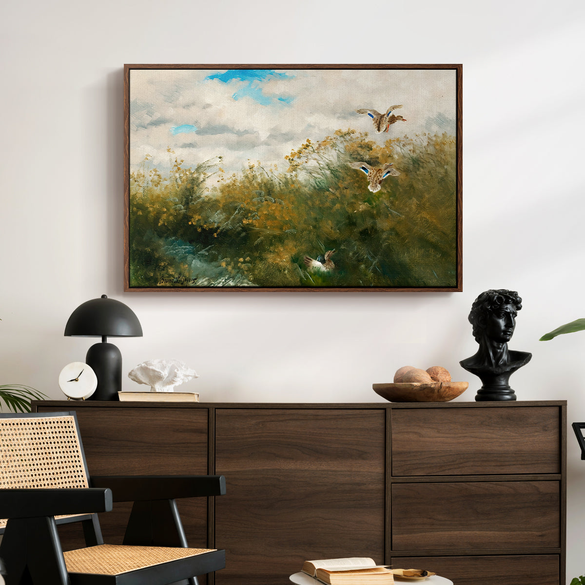 Wild Ducks (Grasänder), 1890 by Bruno Liljefors displayed in a walnut floater framed canvas above a dark wood credenza in an entryway.