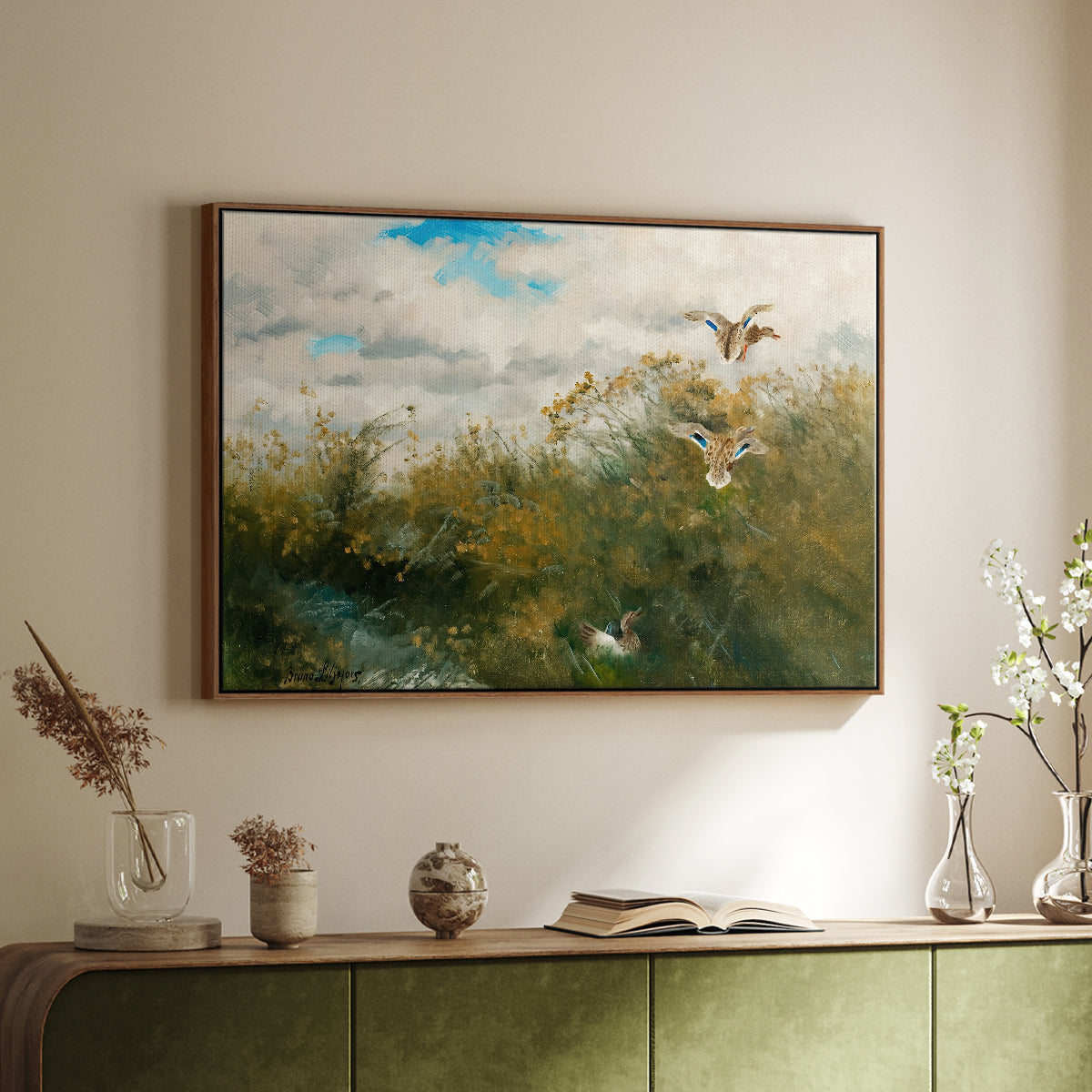 Walnut floater framed canvas of Wild Ducks (Grasänder), 1890 by Bruno Liljefors, featuring a wildlife scene of ducks walking through tall grass beside water above a sideboard in a softly lit hallway.