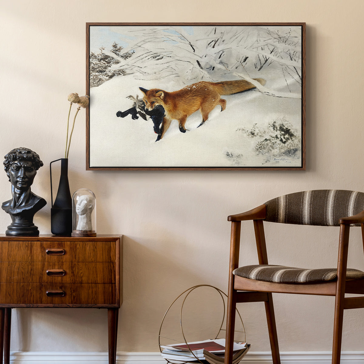 Fox in Snow Landscape, 1900 by Bruno Liljefors as a walnut floater framed canvas featuring a red fox crossing snow-covered ground under pale sky, styled above a mid-century console in a contemporary living area.