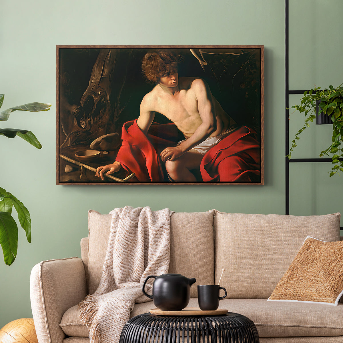 Walnut floater framed canvas featuring a contemplative religious figure in rustic wilderness environment, displayed above a sofa in a modern living room.