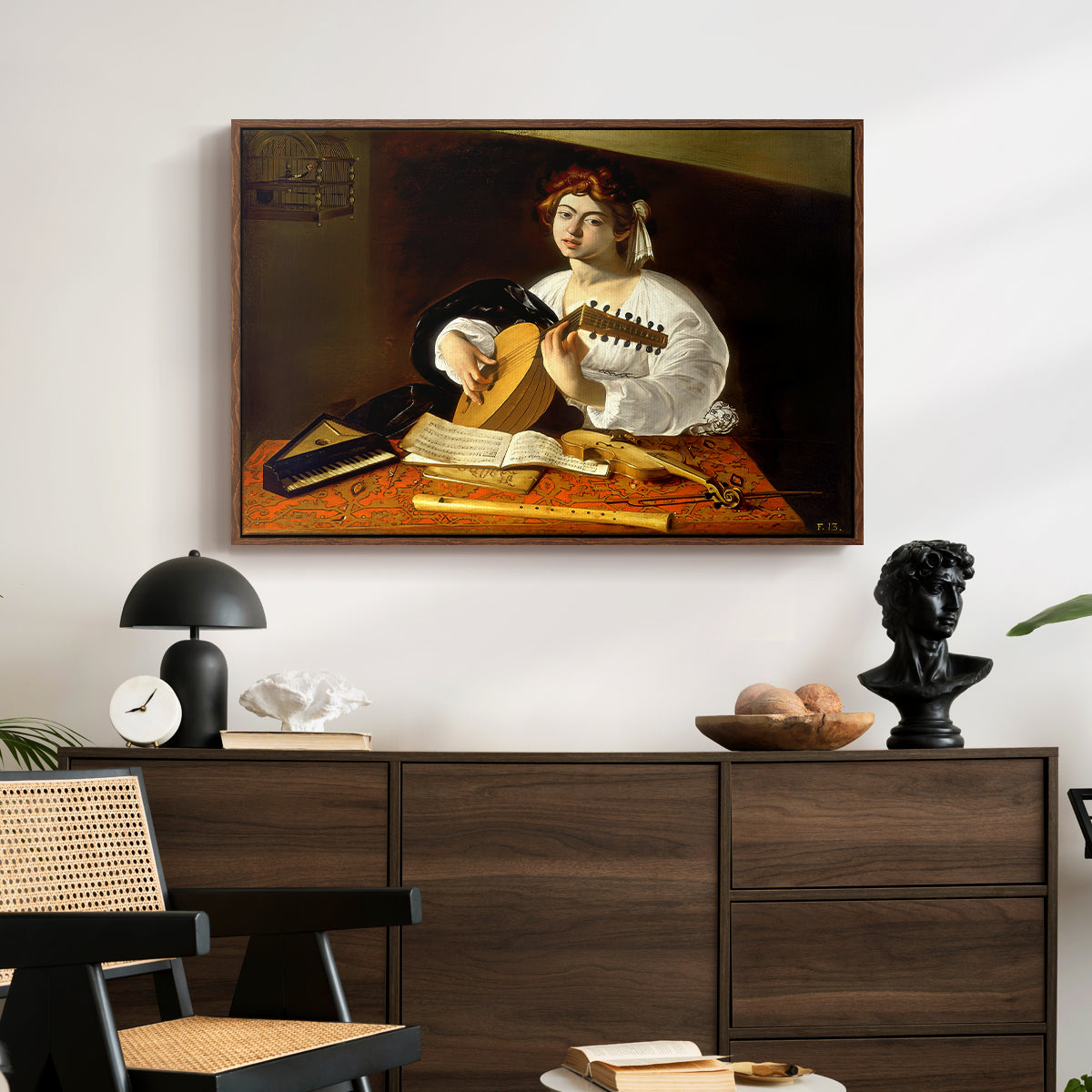 The Lute Player (Wildenstein Version), c. 1596 by Caravaggio displayed in a walnut floater framed canvas above a dark wood credenza in an entryway.