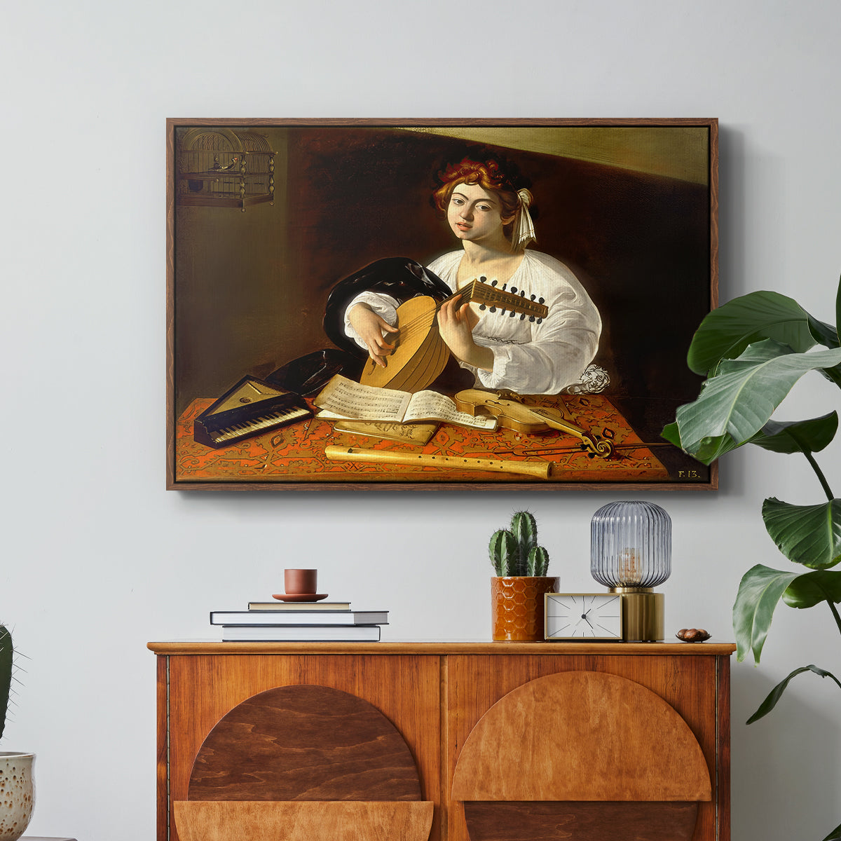 The Lute Player (Wildenstein Version), c. 1596 by Caravaggio in a walnut floater framed canvas featuring a young man playing lute surrounded by sheet music and still life objects, displayed above a wood console cabinet.