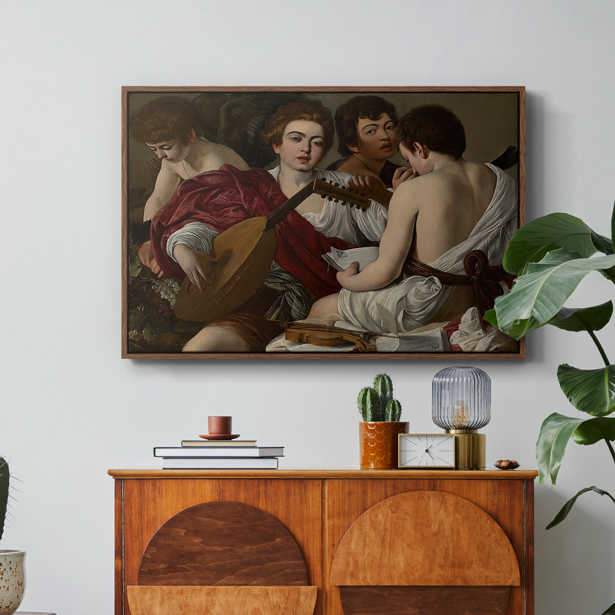 The Musicians, c. 1595 by Caravaggio in a walnut floater framed canvas featuring a group of young men gathered together playing music with instruments, displayed above a wood console cabinet.