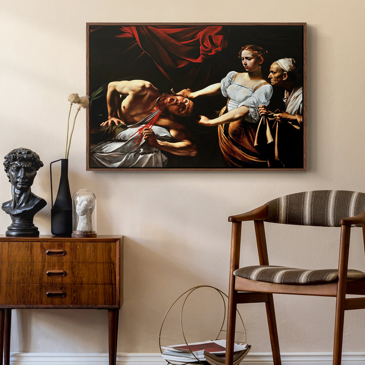 Judith Beheading Holofernes, c. 1599 by Caravaggio as a walnut floater framed canvas featuring an intense moment of Judith slaying Holofernes with sword, styled above a mid-century console in a contemporary living area.