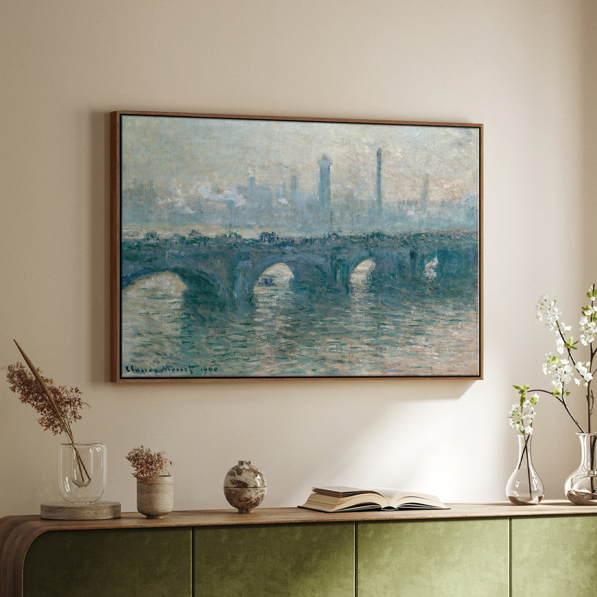 Walnut floater framed canvas of Waterloo Bridge, Gray Weather, 1900 by Claude Monet, featuring an impressionist cityscape with bridge fading into fog over water above a sideboard in a softly lit hallway.