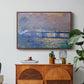 Charing Cross Bridge, 1903 by Claude Monet in a walnut floater framed canvas featuring an impressionist view of bridge stretching across river with soft light and haze, displayed above a wood console cabinet.