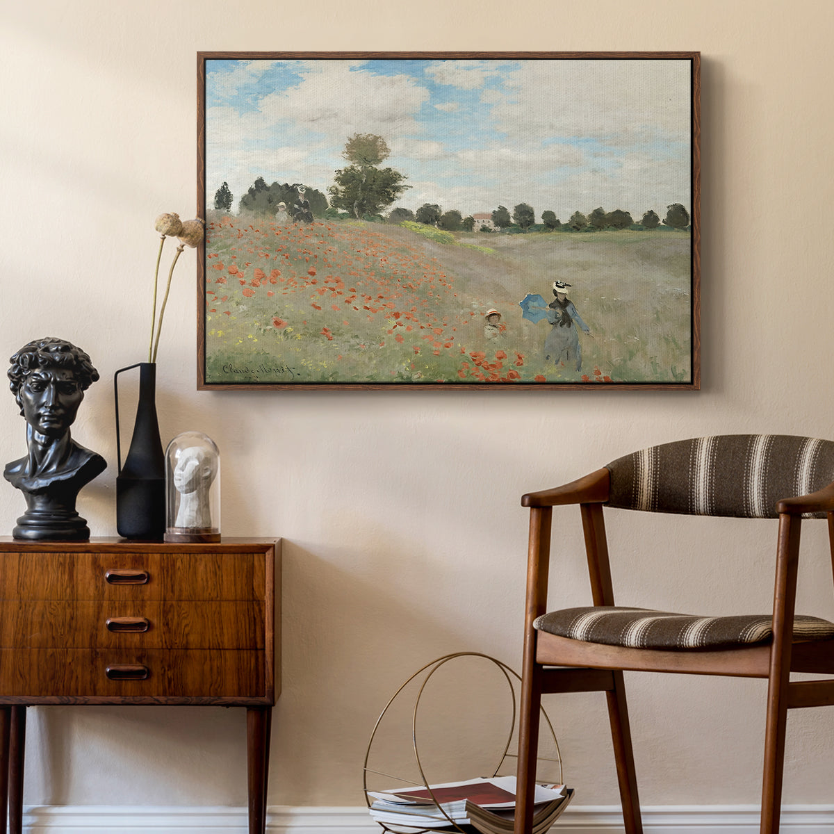 The Poppy Field near Argenteuil, 1873 by Claude Monet as a walnut floater framed canvas featuring a bright meadow filled with poppies under open sky, styled above a mid-century console in a contemporary living area.