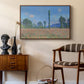 Poppy Field (Giverny), 1890-1891 by Claude Monet as a walnut floater framed canvas featuring a vibrant meadow scene with flowers and vertical tree forms, styled above a mid-century console in a contemporary living area.