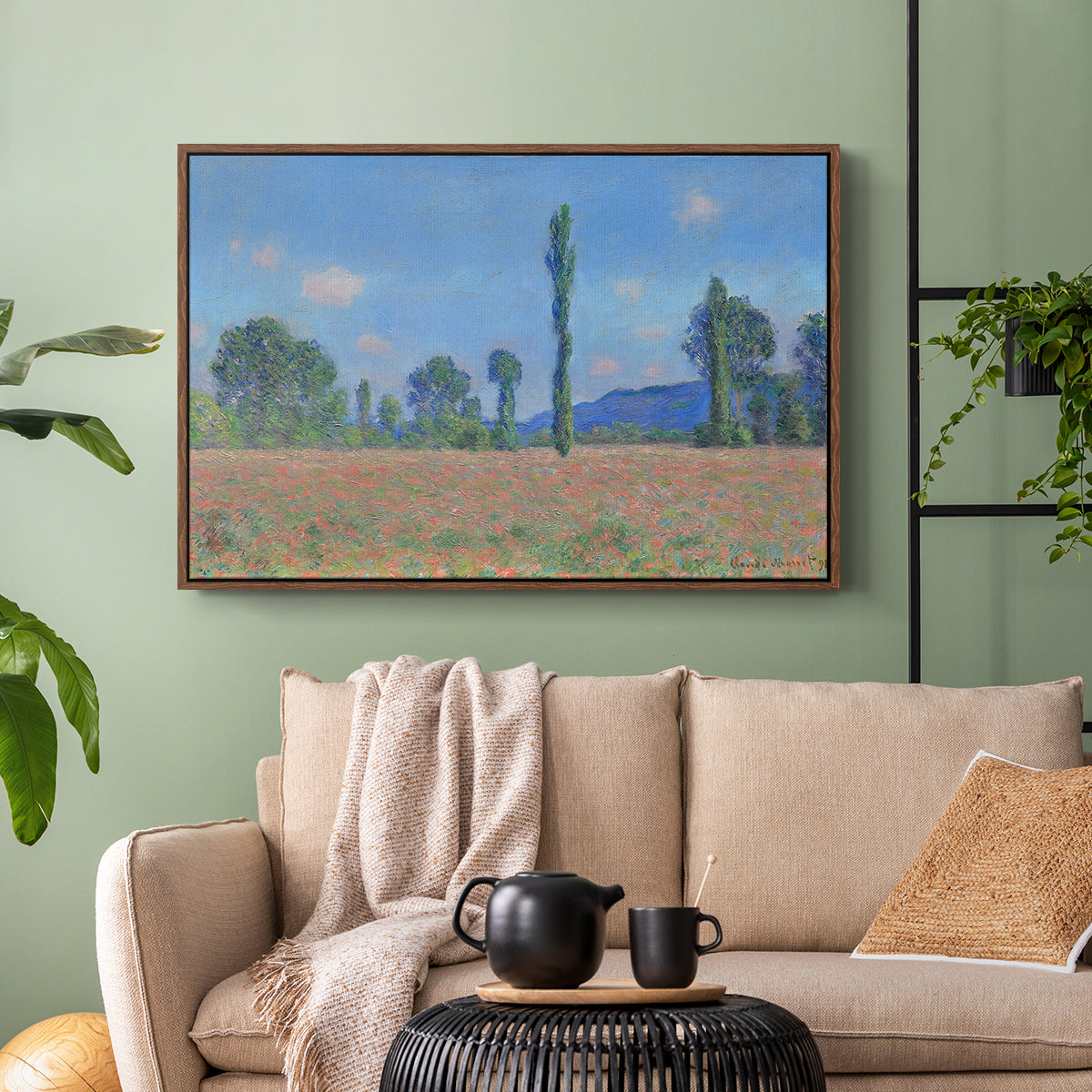Walnut floater framed canvas featuring a rural field filled with red blossoms beneath open sky, displayed above a sofa in a modern living room.