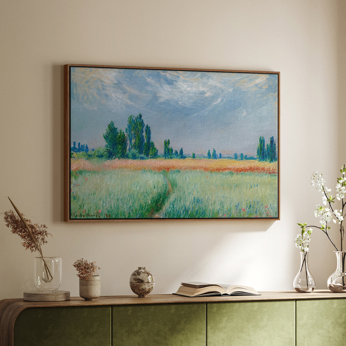 Walnut floater framed canvas of The Wheat Field (Champ de Blé), 1881 by Claude Monet, featuring an impressionist depiction of ripened grain field in countryside above a sideboard in a softly lit hallway.