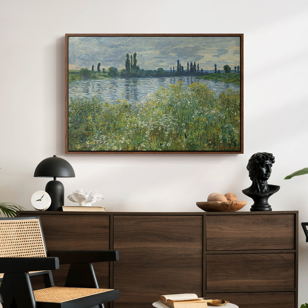 Banks of the Seine, Vétheuil, 1880 by Claude Monet displayed in a walnut floater framed canvas above a dark wood credenza in an entryway.