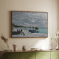 Walnut floater framed canvas of The Beach at Sainte-Adresse, 1867 by Claude Monet, featuring a lively beach scene with people overlooking water and ships above a sideboard in a softly lit hallway.