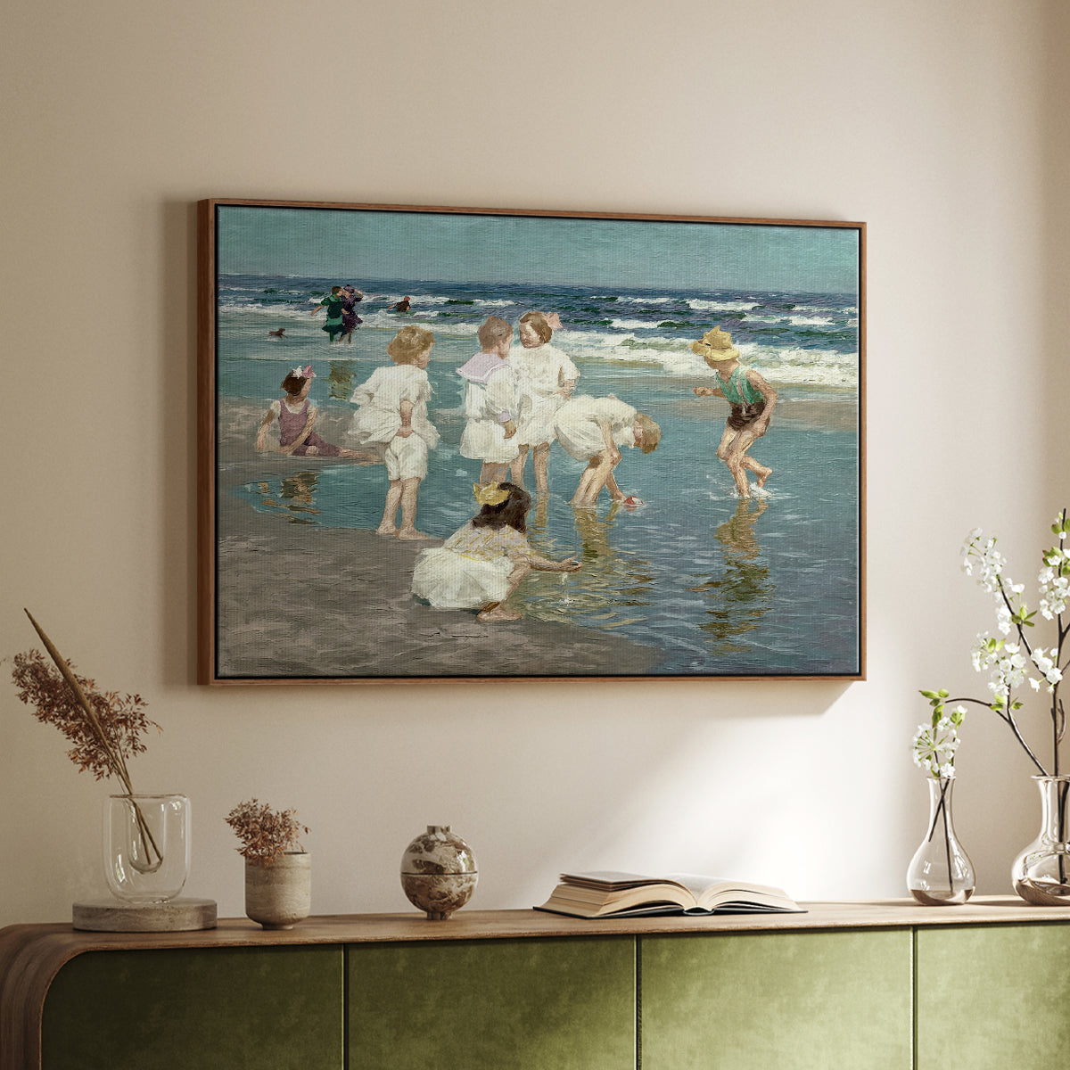 Walnut floater framed canvas of A Holiday, c. 1915 by Edward Henry Potthast, featuring a beach scene with figures bathing and standing in waves under bright sky above a sideboard in a softly lit hallway.