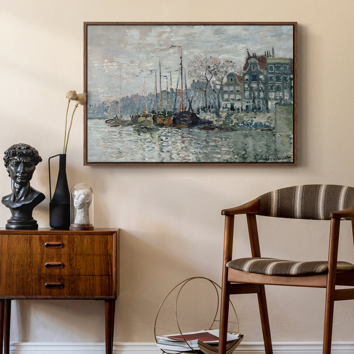 View of the Prins Hendrikkade and Kromme Waal in Amsterdam, 1874 by Claude Monet as a walnut floater framed canvas featuring an urban waterway with docked boats and European buildings, styled above a mid-century console in a contemporary living area.