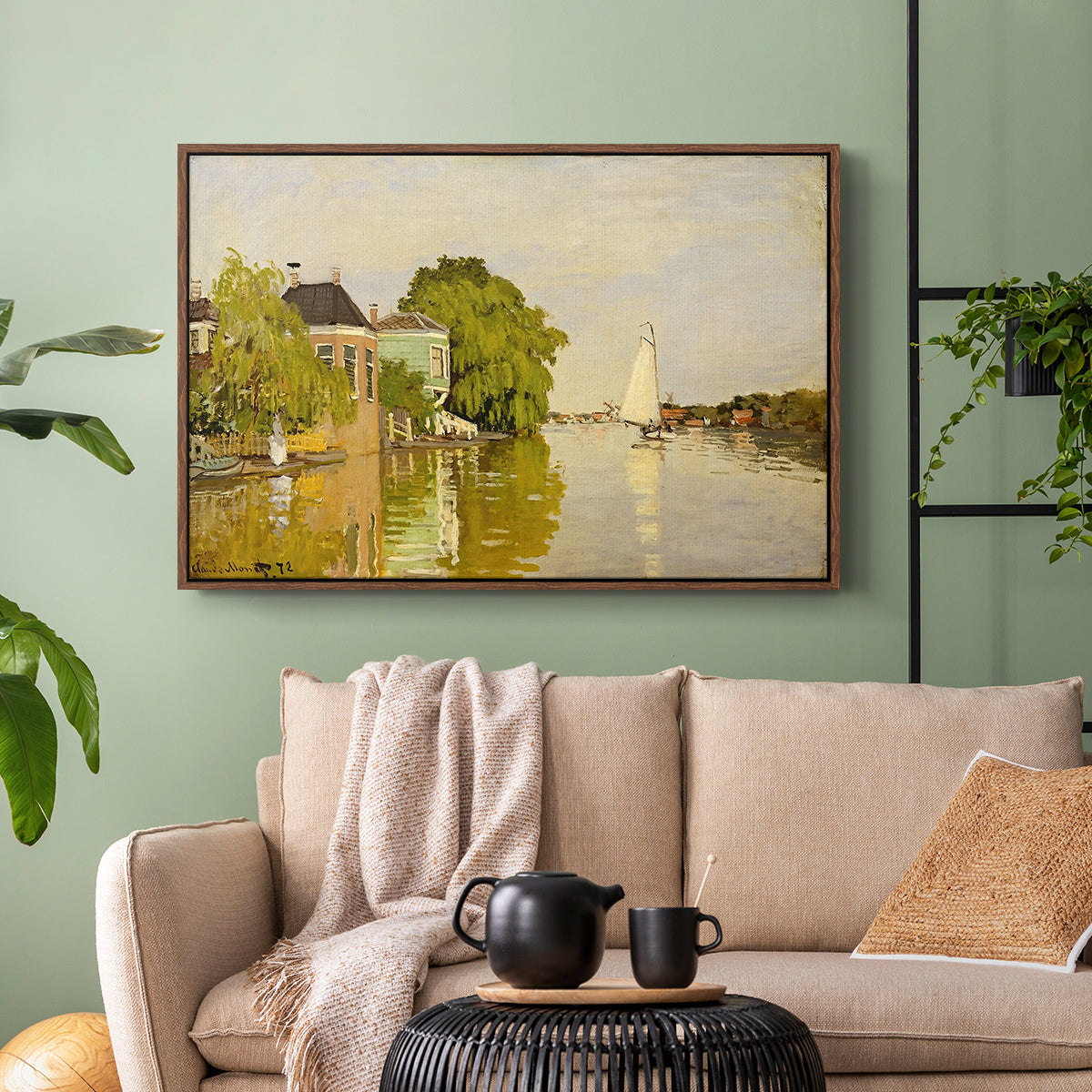 Walnut floater framed canvas featuring a peaceful village scene with houses bordering water, displayed above a sofa in a modern living room.