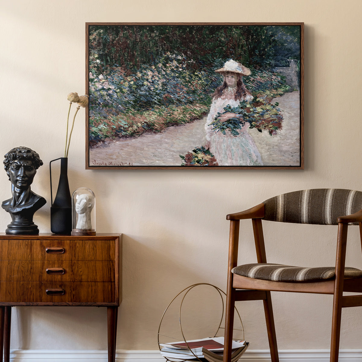 Young Girl in the Garden at Giverny, 1888 by Claude Monet as a walnut floater framed canvas featuring a figure resting in colorful garden under soft light, styled above a mid-century console in a contemporary living area.