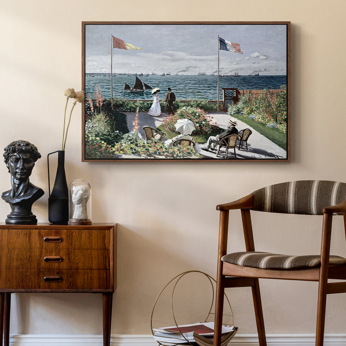 Garden at Sainte-Adresse, 1867 by Claude Monet as a walnut floater framed canvas featuring a vibrant garden scene with colorful blooms and distant sea, styled above a mid-century console in a contemporary living area.