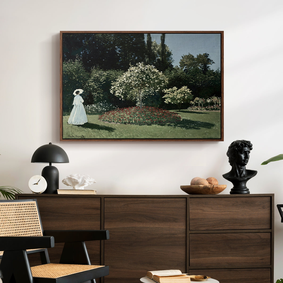Woman in the Garden, Sainte-Adresse, 1867 by Claude Monet displayed in a walnut floater framed canvas above a dark wood credenza in an entryway.