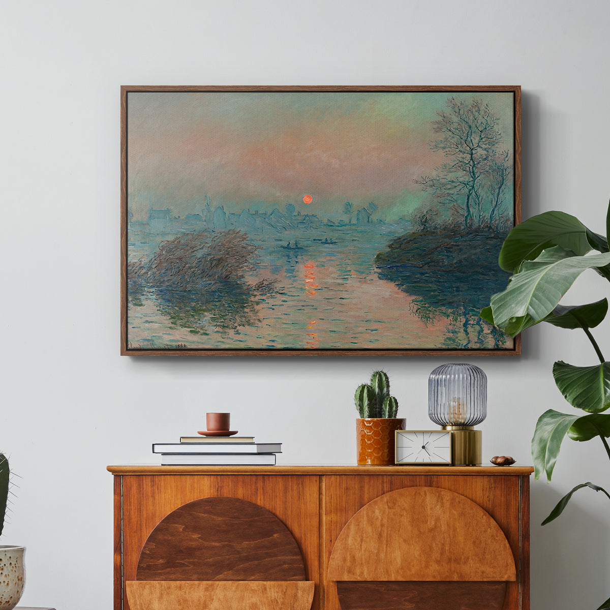 Sunset on the Seine at Lavacourt, Winter Effect, 1880 by Claude Monet in a walnut floater framed canvas featuring a glowing sunset over snowy river landscape with soft reflections, displayed above a wood console cabinet.