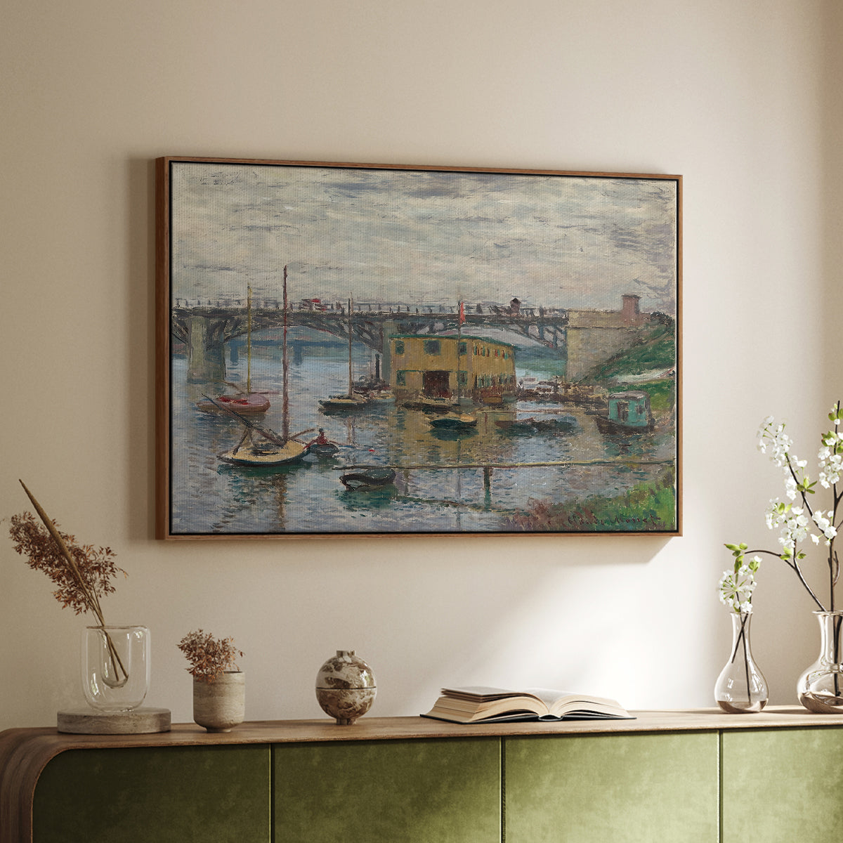 Walnut floater framed canvas of Bridge at Argenteuil on a Gray Day, c. 1876 by Claude Monet, featuring an impressionist riverscape with overcast atmosphere and soft tones above a sideboard in a softly lit hallway.