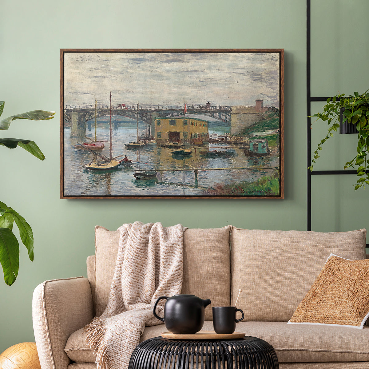 Walnut floater framed canvas featuring a subdued urban landscape with structure spanning river, displayed above a sofa in a modern living room.