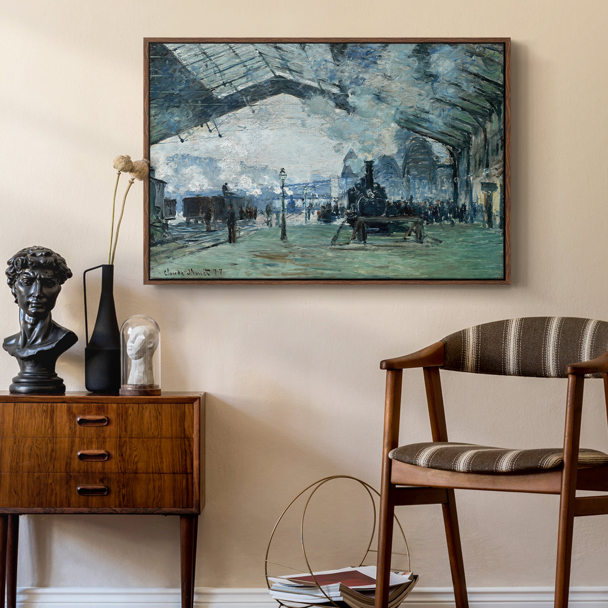 The Saint-Lazare Station, 1877 by Claude Monet as a walnut floater framed canvas featuring an interior view of station filled with movement and smoke, styled above a mid-century console in a contemporary living area.