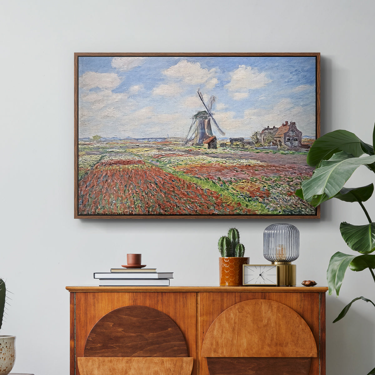 Tulip Fields with the Rijnsburg Windmill, 1886 by Claude Monet in a walnut floater framed canvas featuring colorful rows of tulip fields leading toward distant windmill, displayed above a wood console cabinet.
