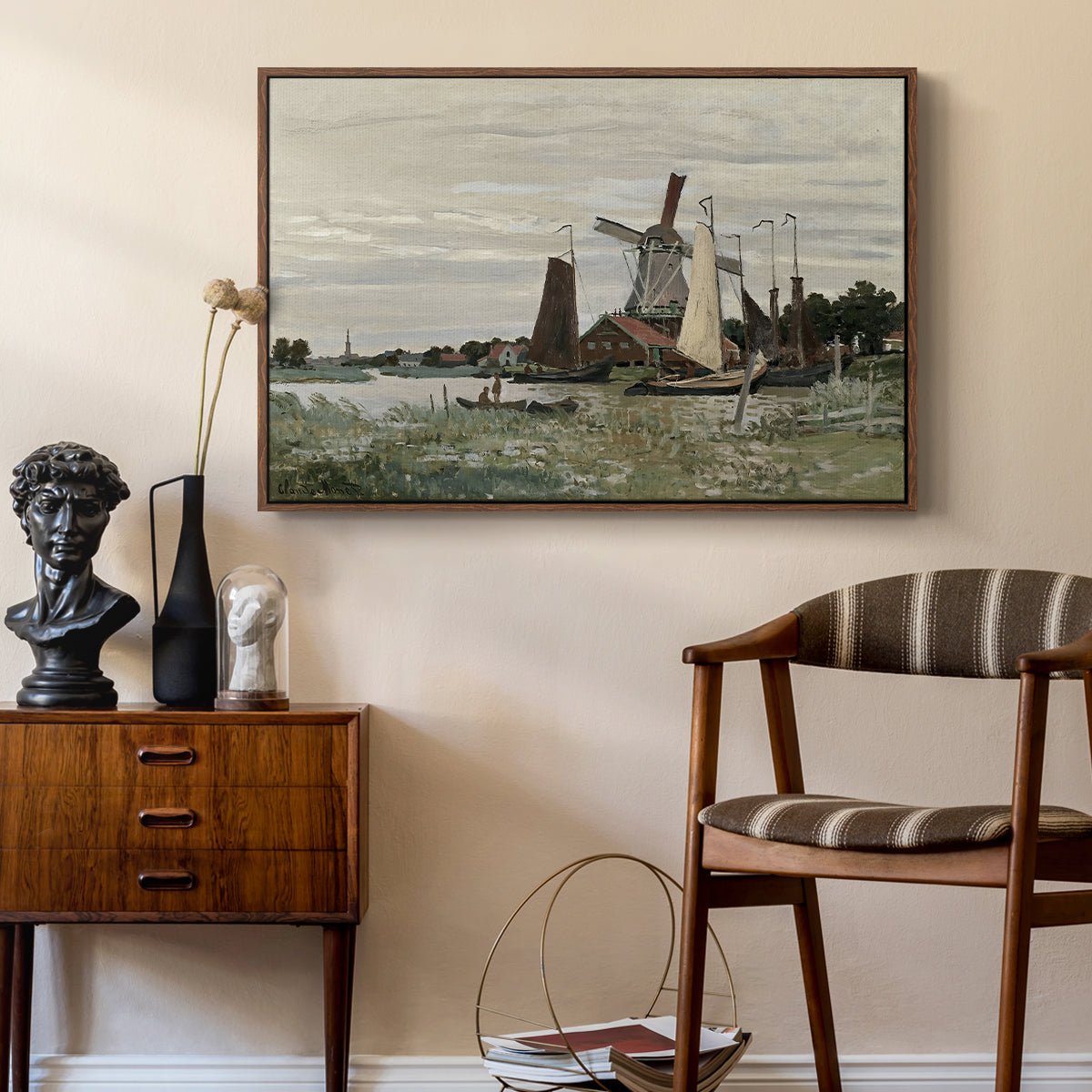 Windmill at Zaandam, 1871 by Claude Monet as a walnut floater framed canvas featuring a rustic scene with windmill and reflections in water, styled above a mid-century console in a contemporary living area.