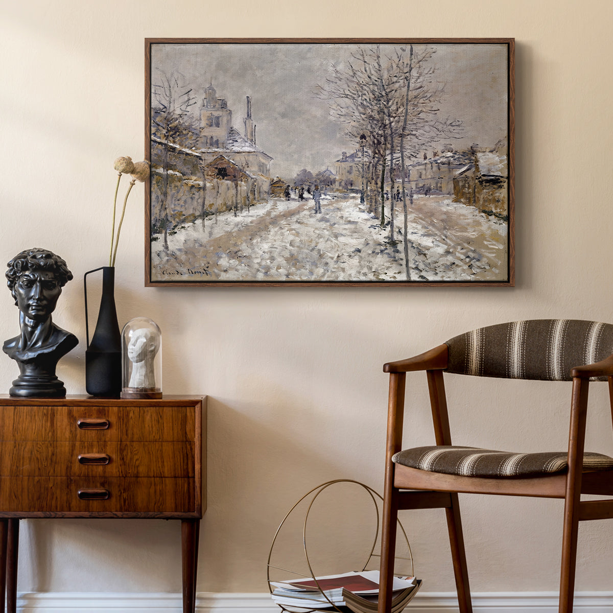 The Boulevard de Pontoise at Argenteuil, Snow Effect, 1875 by Claude Monet as a walnut floater framed canvas featuring a quiet boulevard blanketed in snow with distant figures, styled above a mid-century console in a contemporary living area.