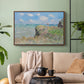 Walnut floater framed canvas featuring an elevated shoreline path with figures and bright sky, displayed above a sofa in a modern living room.