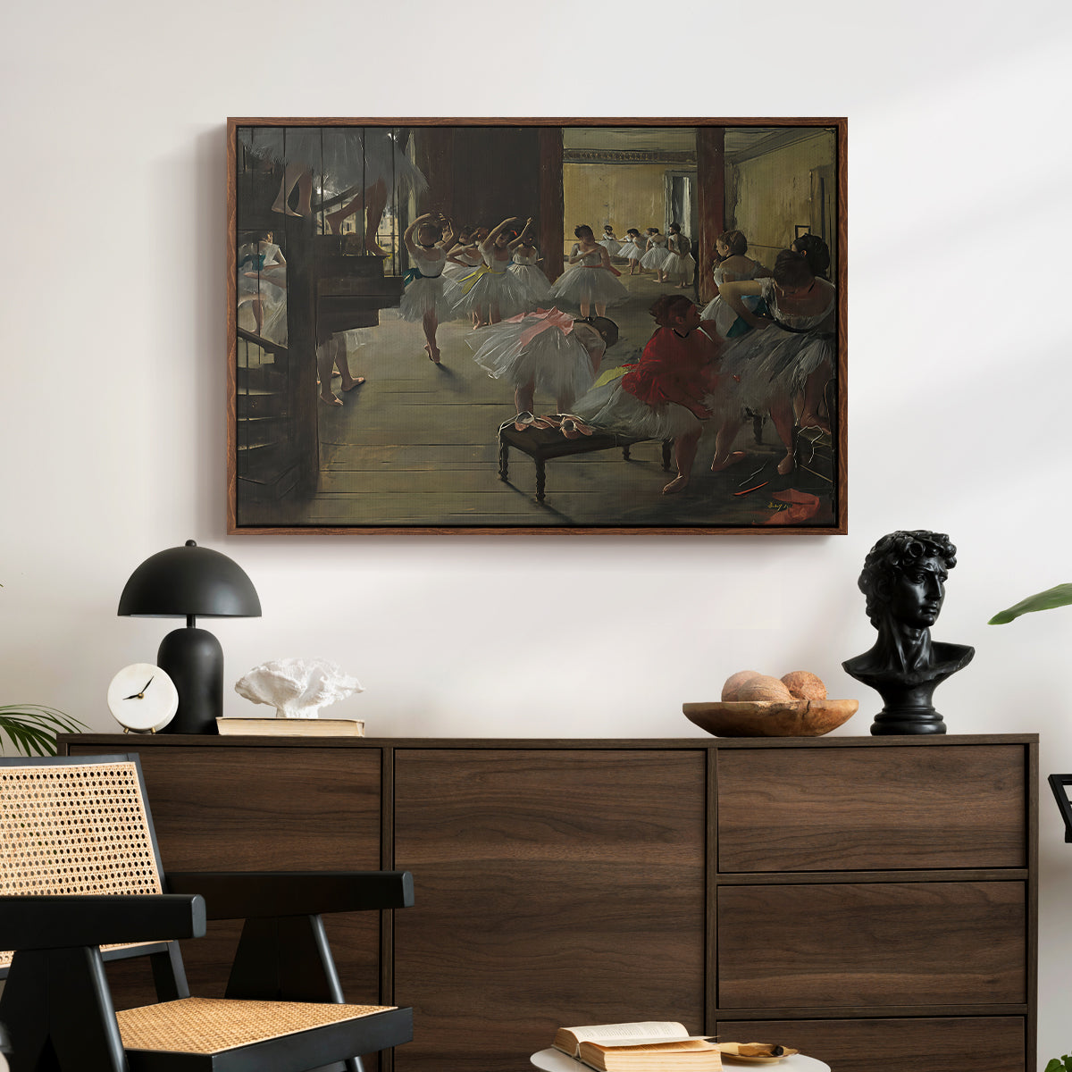 The Dance Class, c. 1873 by Edgar Degas displayed in a walnut floater framed canvas above a dark wood credenza in an entryway.