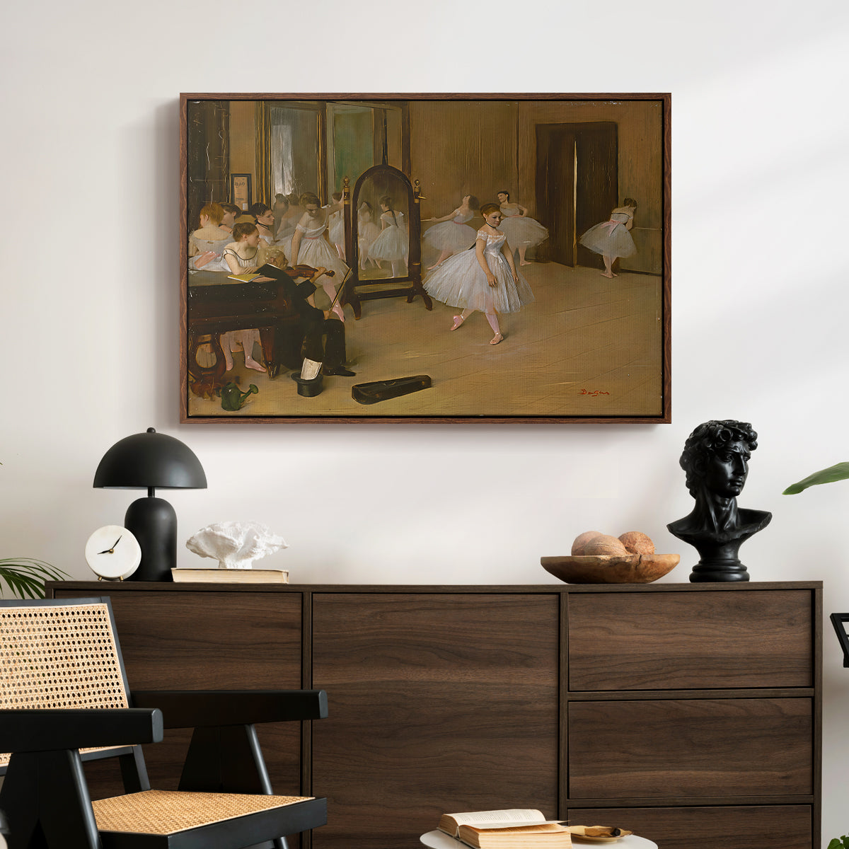 The Dancing Class, c. 1870 by Edgar Degas displayed in a walnut floater framed canvas above a dark wood credenza in an entryway.