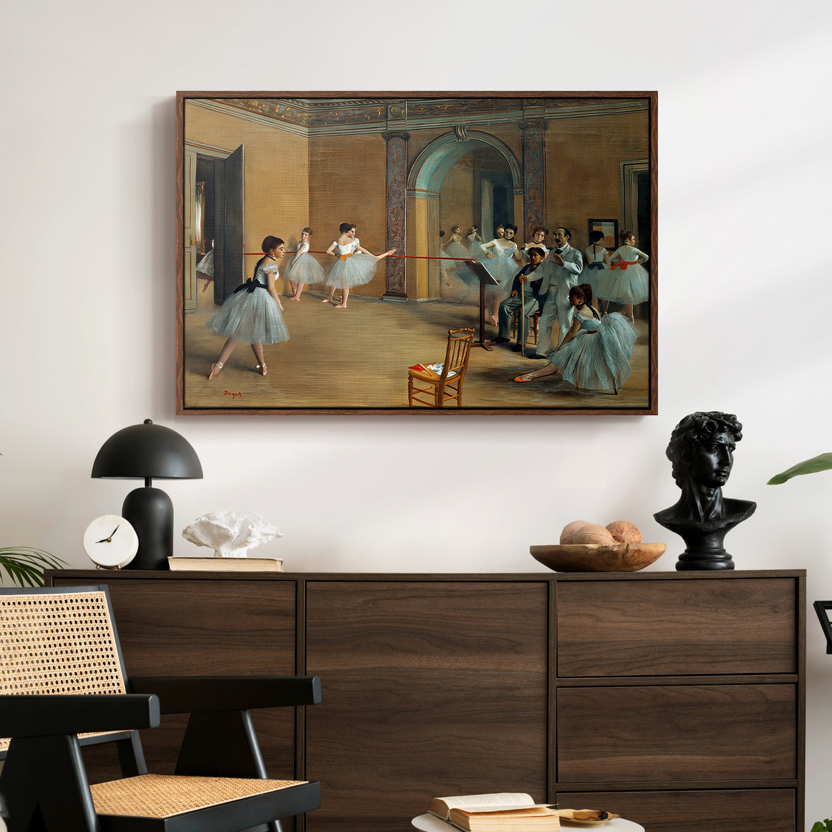 The Dance Foyer at the Opera on the Rue Le Peletier, 1872 by Edgar Degas displayed in a walnut floater framed canvas above a dark wood credenza in an entryway.