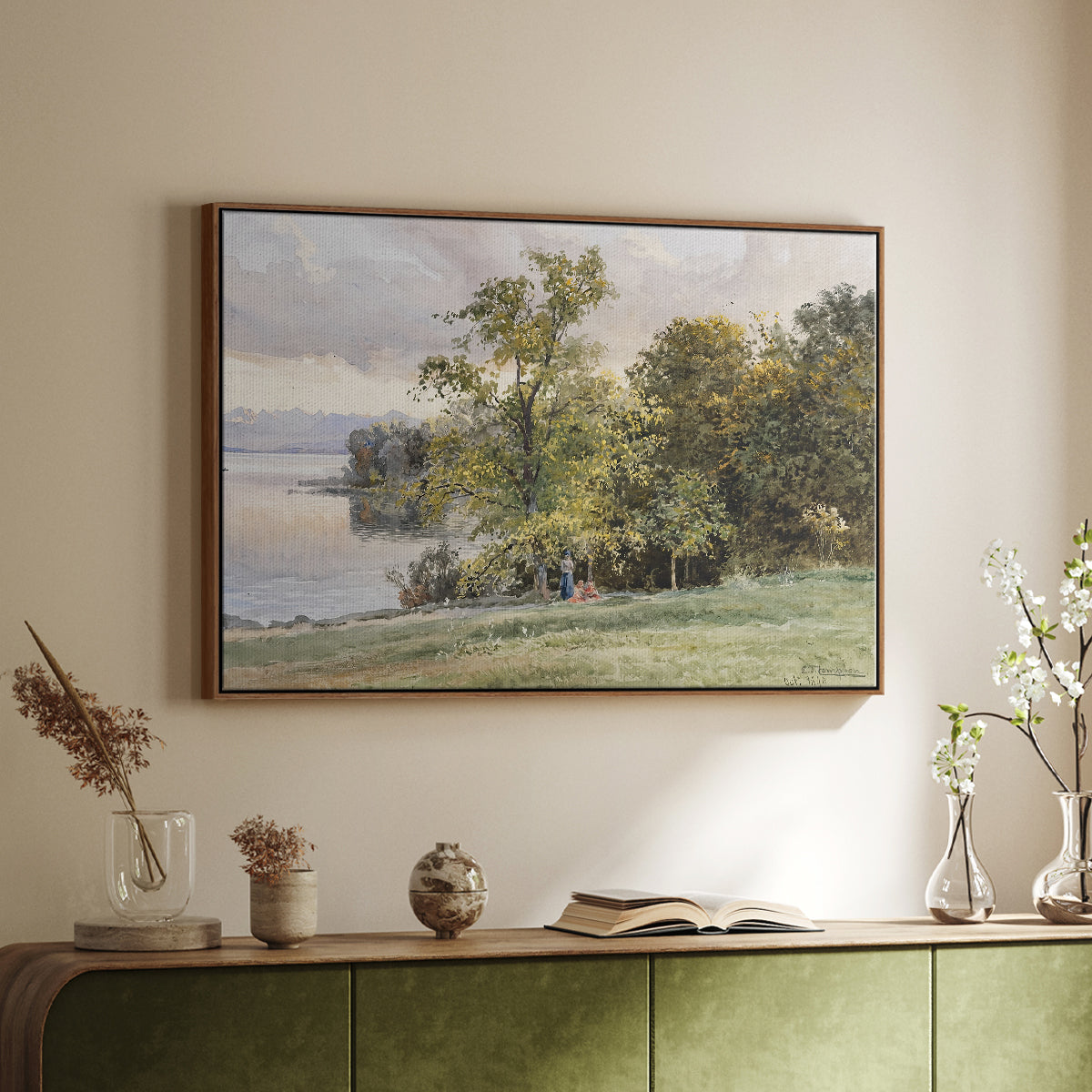 Walnut floater framed canvas of Landscape at Lake Starnberg, 1890 by Edward Theodore Compton, featuring a peaceful lake scene with reflections and surrounding greenery above a sideboard in a softly lit hallway.