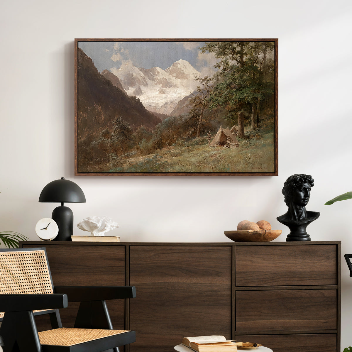 Landscape in the Caucasus, c. 1921 by Edward Theodore Compton displayed in a walnut floater framed canvas above a dark wood credenza in an entryway.